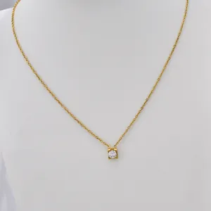 Close-up of a minimalist gold stainless steel necklace with a round zircon pendant