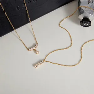 Primer plano de collares de acero inoxidable bañados en oro 18K con colgantes de circonita.