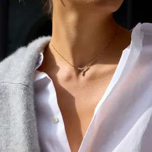 Detalle de un delicato collar de acero inoxidable chapado en oro de 18K con gota de circón.