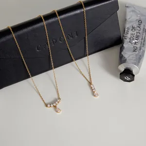 Primer plano de collares de circón dispuestos sobre una bolsa negra con accesorios de lujo