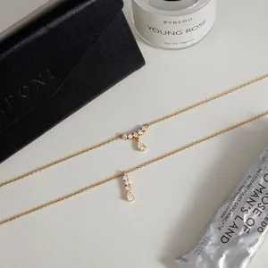 Primer plano de collar de acero inoxidable chapado en oro de 18K con circón de gota