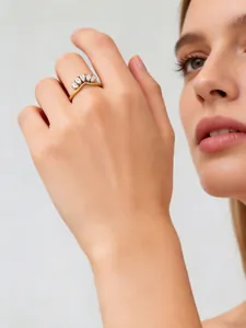 Detailed macro view of a golden stainless steel ring featuring pear-shaped zircon stones