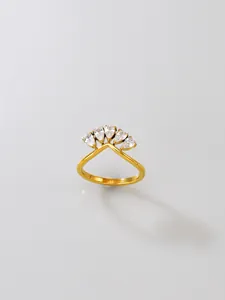 Detail view of golden stainless steel ring with pear-shaped cubic zirconia crown