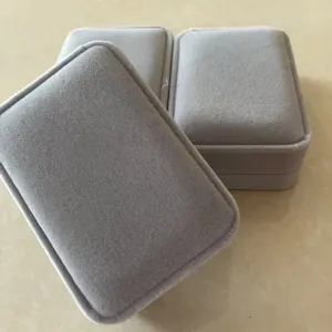 Primer plano de tres cajas de terciopelo gris para joyas, perfectas para regalo y exhibición