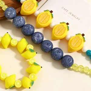 Macro detail of vibrant fruit-themed beads featuring lemon and blueberry shapes