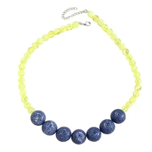 Detailed view of yellow translucent and blue patterned beads on a fruit-themed necklace