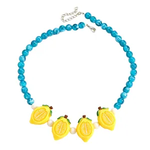 Close-up shot of vibrant blue swirl bead necklace featuring four yellow resin lemon charms