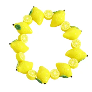 Detailed macro view of a yellow lemon fruit bead necklace with sliced lemon accents.