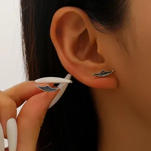 Dettaglio di orecchini gotici a mezzaluna con intricati motivi incisi e stile vintage.
