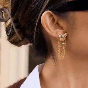 Detail of 18K gold plated stainless steel earrings with white zircon tassels on ear.