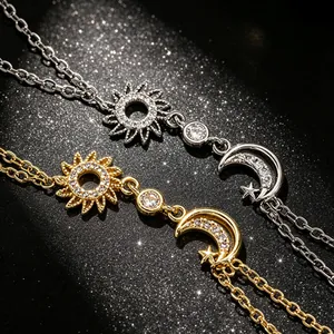 Détail des chaînes de main soleil et lune avec zircons en finitions or et argent.