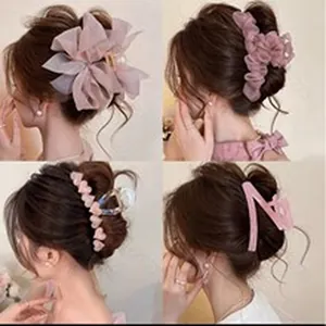 Close-up of four different styles of elegant pink fabric hair claw clips for women's hair