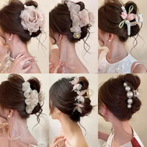 Variety of elegant floral and pearl hair claw clips shown on model for versatile hairstyles