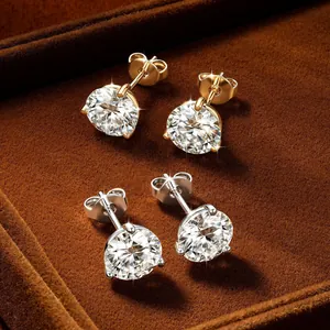 Primer plano de pendientes de moissanita con tres garras en oro y plata brillantes
