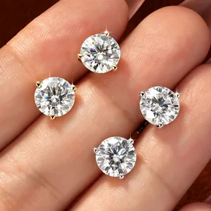 Primer plano detallado de pendientes brillantes de moissanita redonda en la mano
