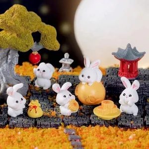 Macro shot of cute miniature rabbit figurines in a festive micro-landscape scene.