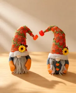 Gnomes d'automne faits main avec citrouilles et tournesols dans un décor chaleureux.