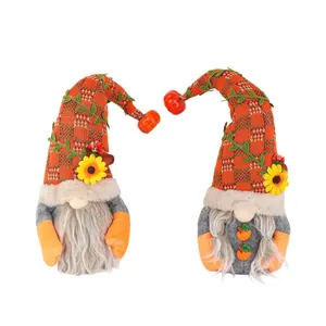 Paire de gnomes de la récolte d'automne avec citrouilles et tournesols