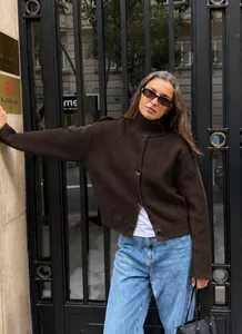 Gilet en maille marron chic associé à un jean bleu pour un look de rue urbain moderne.