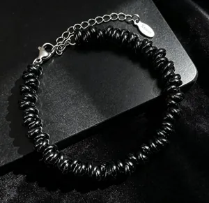 Détail d'un bracelet hip-hop en acier inoxydable avec des perles en spirale noires uniques.