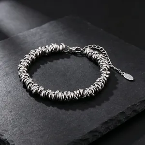 Détail macro du bracelet en acier inoxydable texturé avec anneaux entrelacés solides