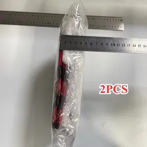 Mesure de profil de 2 sacs-cadeaux de Noël à carreaux rouges et noirs dans leur emballage.