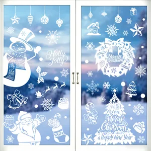 Detailed view of festive white silhouette Christmas window decals on a glass door pane.