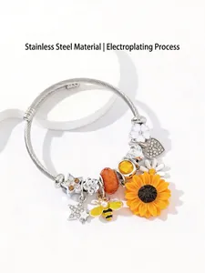 Primo piano dettagliato di un bracciale in acciaio inossidabile con ciondoli girasole e ape