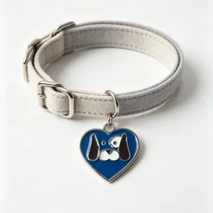 Detail of a gray and cream pet collar with a blue heart-shaped dog face pendant.