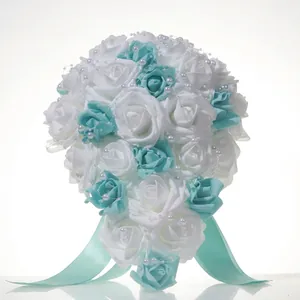 Close-up of white and turquoise rose wedding bouquet with pearl accents and ribbons