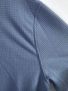 Detailed close-up showing the blue waffle-knit fabric texture of a men's sweatshirt