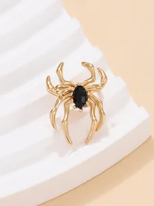 Detailansicht eines goldfarbenen Spinnenohrrings mit einem schwarzen Schmuckstein