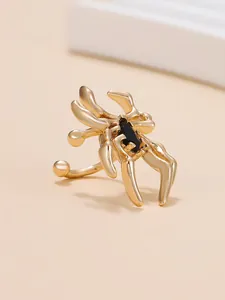 Detaillierte Nahaufnahme einer goldfarbenen Spinnen-Ohrmanschette mit schwarzem Stein