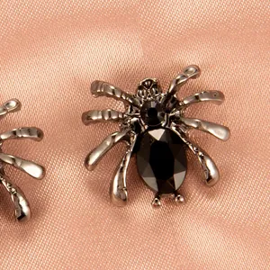 Nahaufnahme eines gotischen schwarzen Spinne-Ohrsteckers mit geschliffenen Strasssteinen