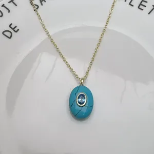 Gros plan d'un collier pendentif turquoise en forme d'œuf avec un centre en zircon bleu