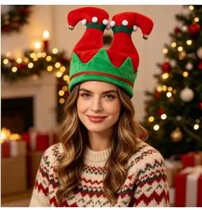 Weibliches Model trägt einen kreativen rot-grünen Weihnachts-Elfenhut mit Glöckchen