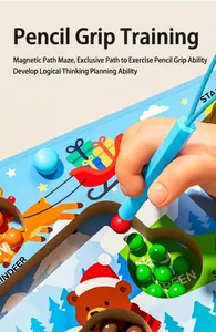 Detail of child using magnetic pen to move colorful beads in wooden Christmas maze