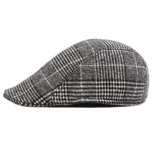 Detail of grey plaid wool flat cap for men, showing textured fabric and classic pattern.
