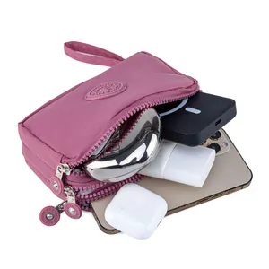 Mauve water-resistant nylon phone pouch with triple zipper compartments and wrist strap