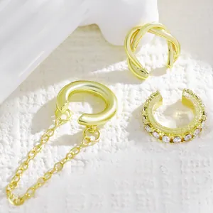Macro view of vintage gold C-shaped ear cuff set with chain and rhinestone details