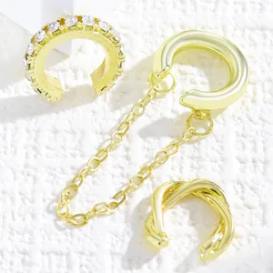 Detailed macro view of vintage gold C-shaped ear cuff set featuring rhinestones and chain