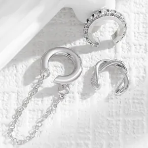 Close-up of vintage silver C-shaped ear cuff set with zirconia and chain details