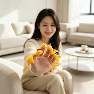 Funny yellow rubber slingshot chicken stress relief toy shown on fingers for office or home play