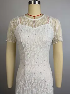 Detailopname van een witte kanten jurk met slim-fit pasvorm en lovertjes.