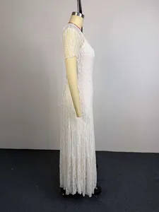 Gedetailleerd zijaanzicht van een elegante witte kanten maxi-jurk met korte mouwen