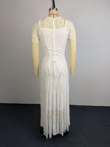 Gedetailleerd achteraanzicht van witte kanten maxi-jurk met een elegante vetersluiting.