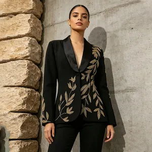 Close-up of elegant black blazer with intricate gold leaf embroidery and satin shawl collar.