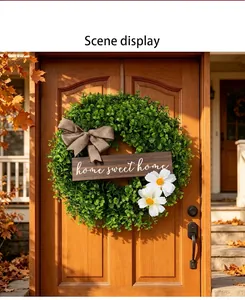 Artificial green boxwood wreath with home sweet home sign on a wooden door