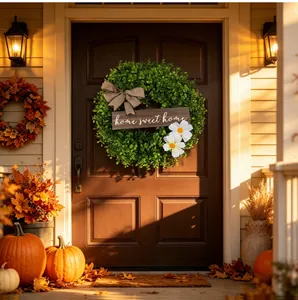 Artificial green leaf wreath with 'Home Sweet Home' sign on a classic brown front door.