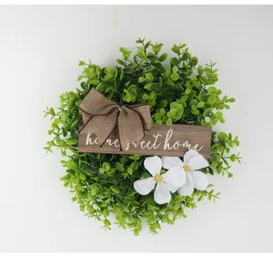 Artificial green foliage wreath with rustic burlap bow and home sweet home wooden plaque